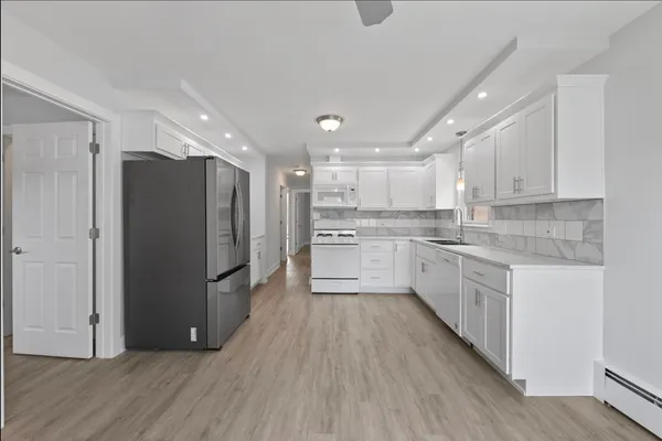 a kitchen with a refrigerator a sink and cabinets
