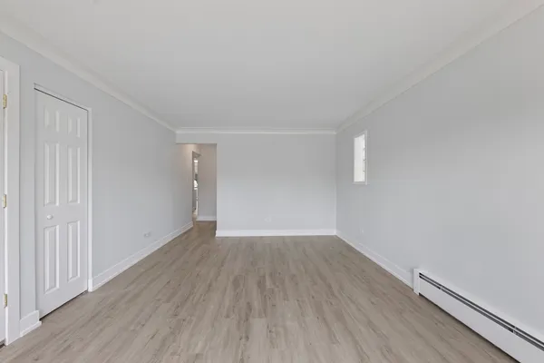 a view of an empty room with wooden floor