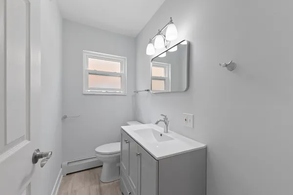 a bathroom with a toilet a sink and mirror