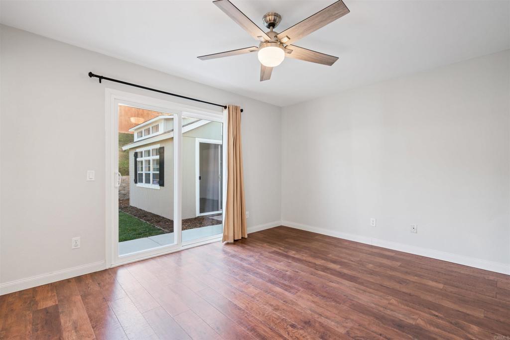 4435 Springtime Drive Oceanside, CA 92056 - Photo 13 of 22 an empty room with wooden floor fan and windows