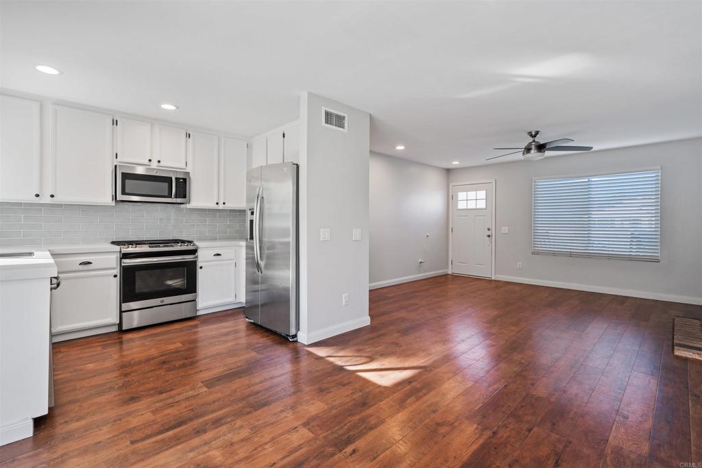4435 Springtime Drive Oceanside, CA 92056 - Photo 7 of 22 a kitchen with granite countertop a refrigerator and a stove top oven