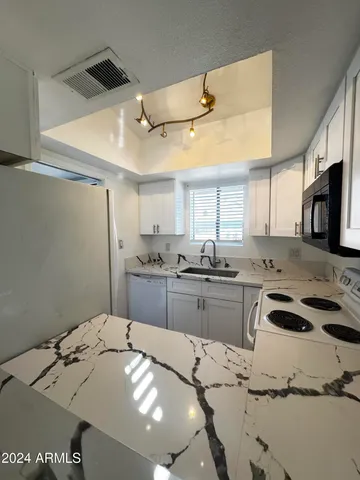 a kitchen with a sink a stove a microwave and cabinets