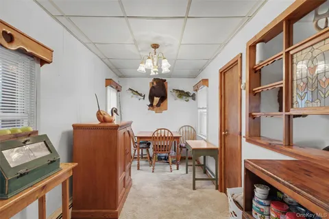 a view of a dining room with furniture a chandelier and wooden floor