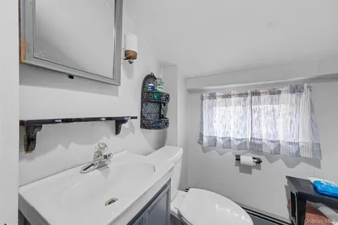 a bathroom with a sink toilet and mirror