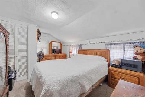 a bedroom with a bed and dresser with mirror