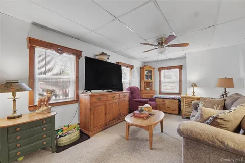 a living room with furniture a flat screen tv and a window