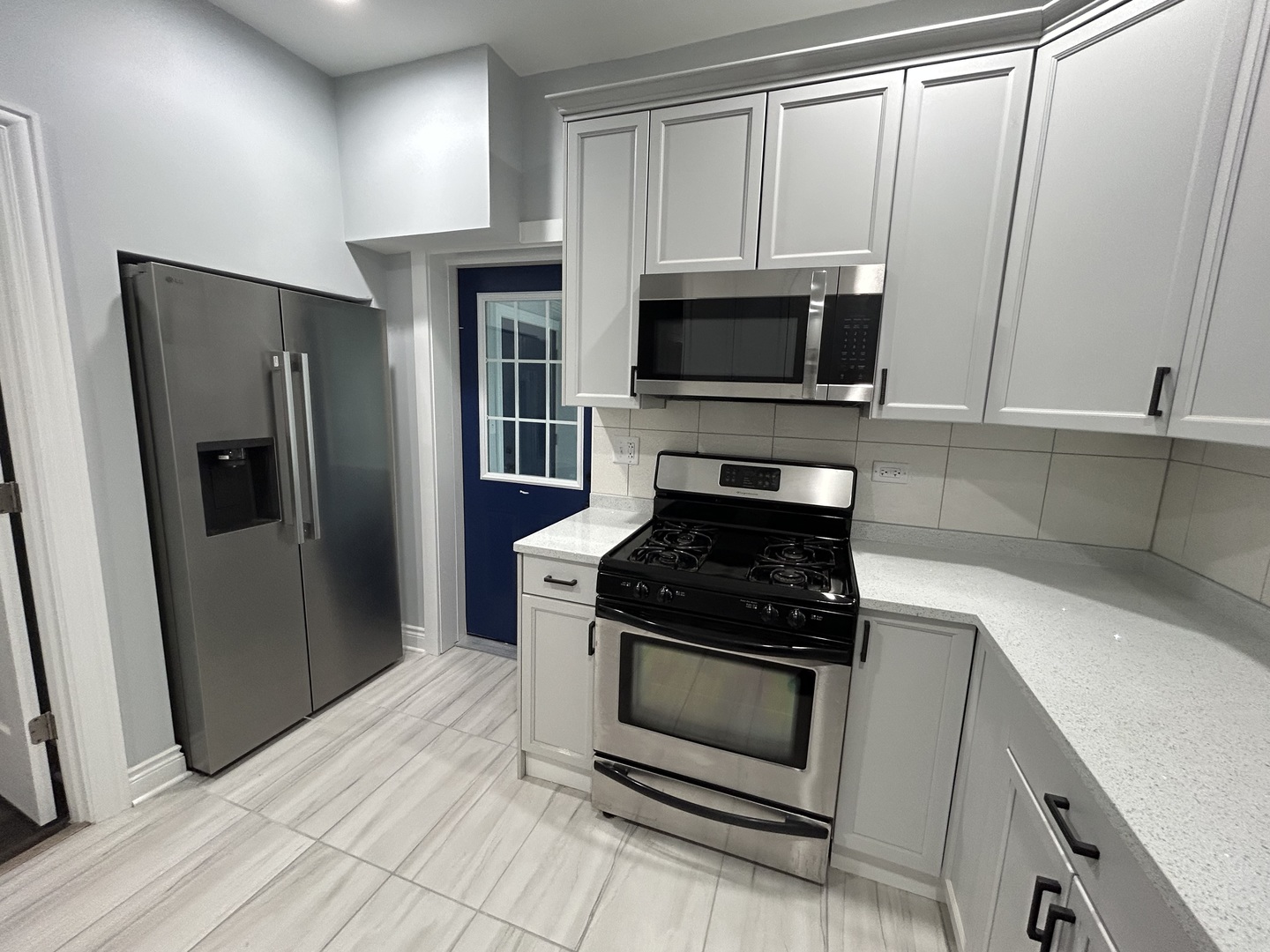 7940 South Carpenter Street, Unit 2 Chicago, IL 60620 - Photo 19 of 34 a kitchen with white cabinets and stainless steel appliances