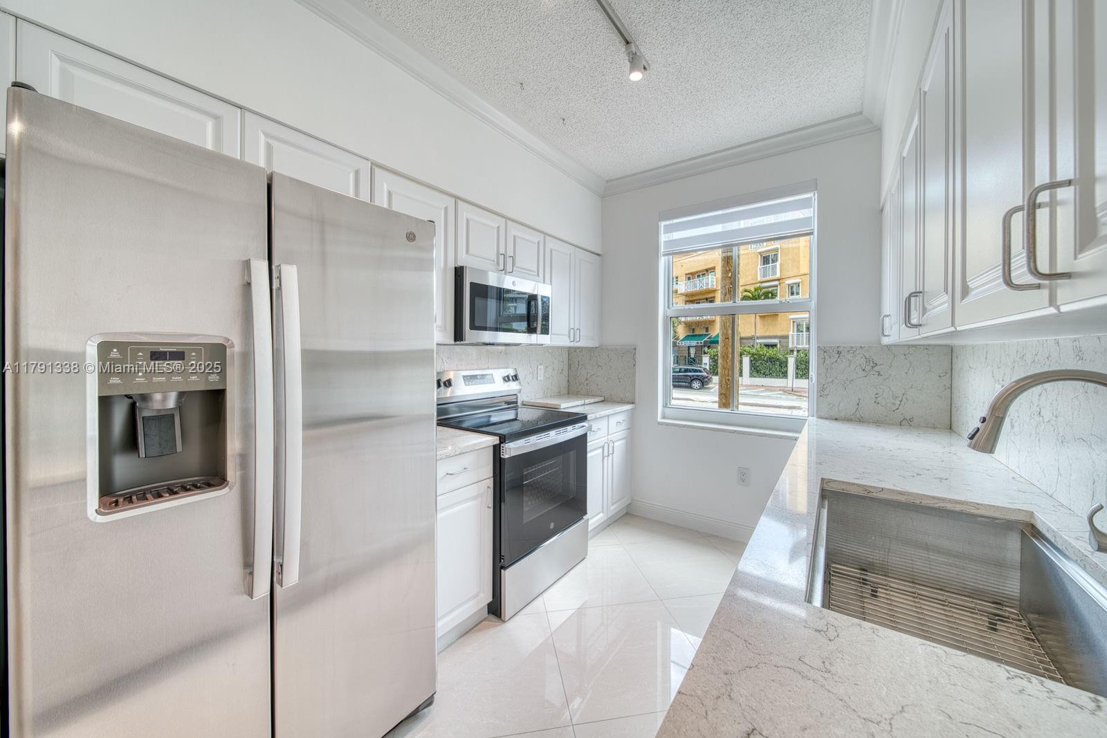 90 Alton Road, Unit TH2 Miami Beach, FL 33139 - Photo 7 of 32 a large kitchen with a refrigerator a stove top oven a sink and dishwasher