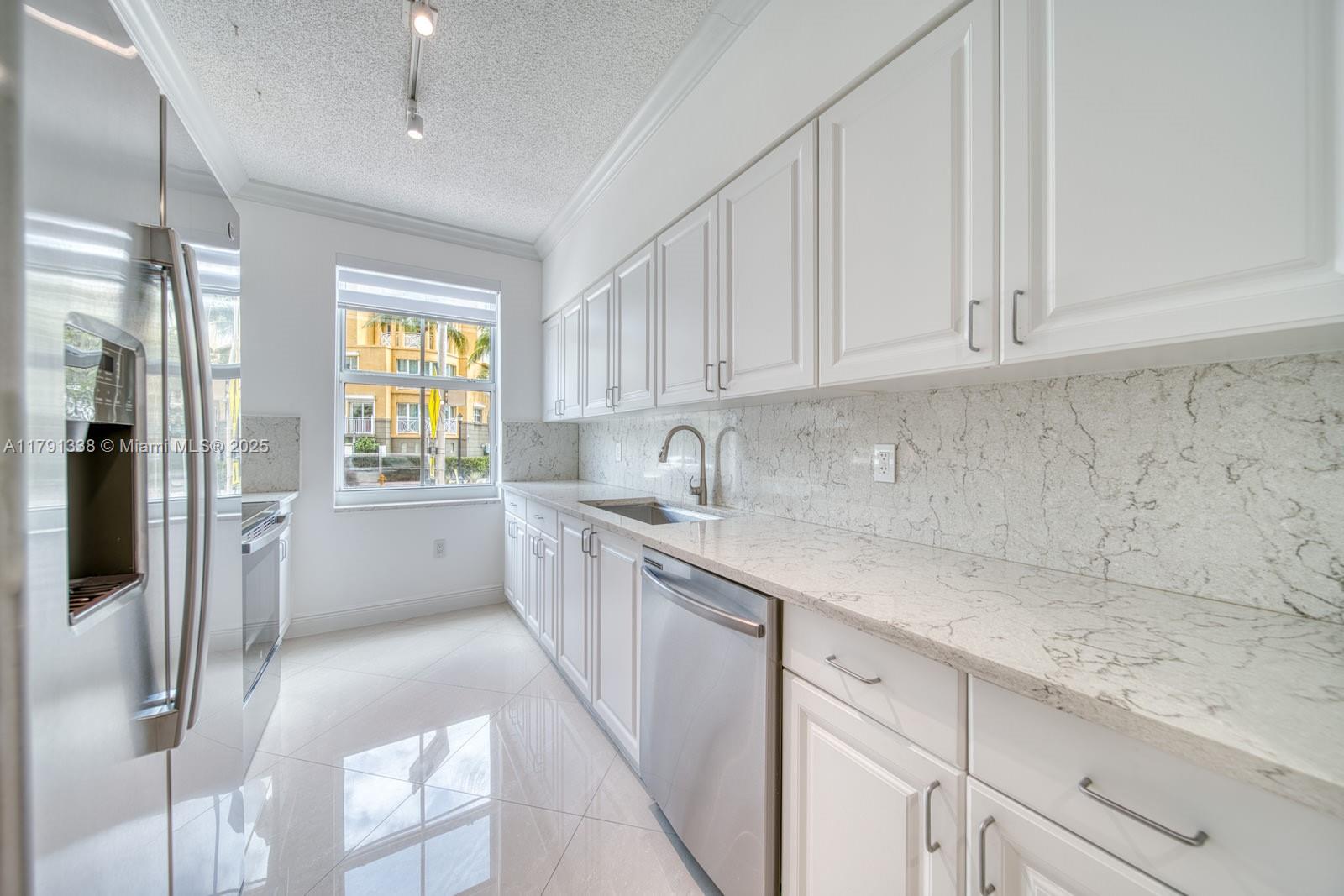 90 Alton Road, Unit TH2 Miami Beach, FL 33139 - Photo 9 of 32 a kitchen with a sink and cabinets
