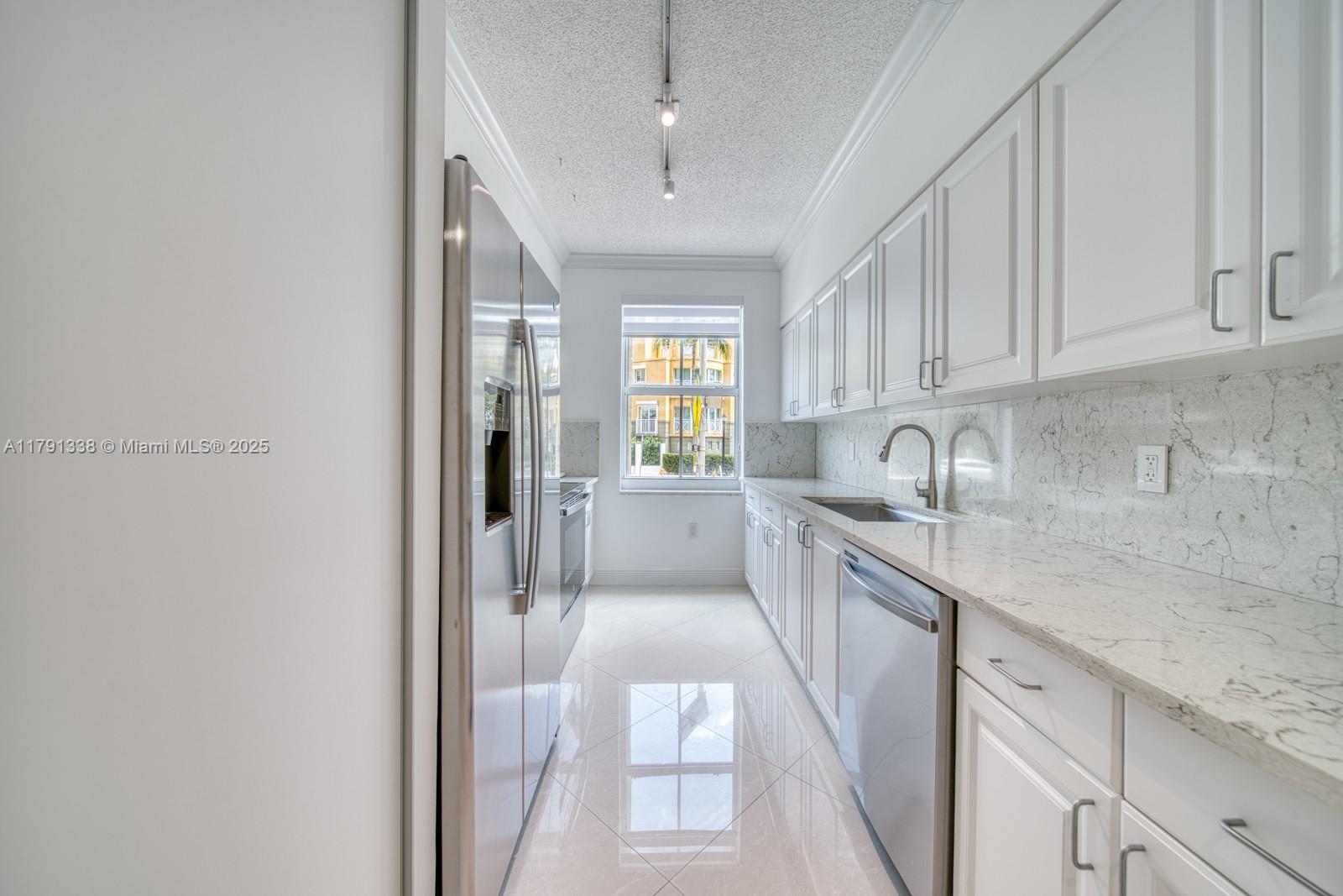 90 Alton Road, Unit TH2 Miami Beach, FL 33139 - Photo 10 of 32 a large white kitchen with granite countertop a sink