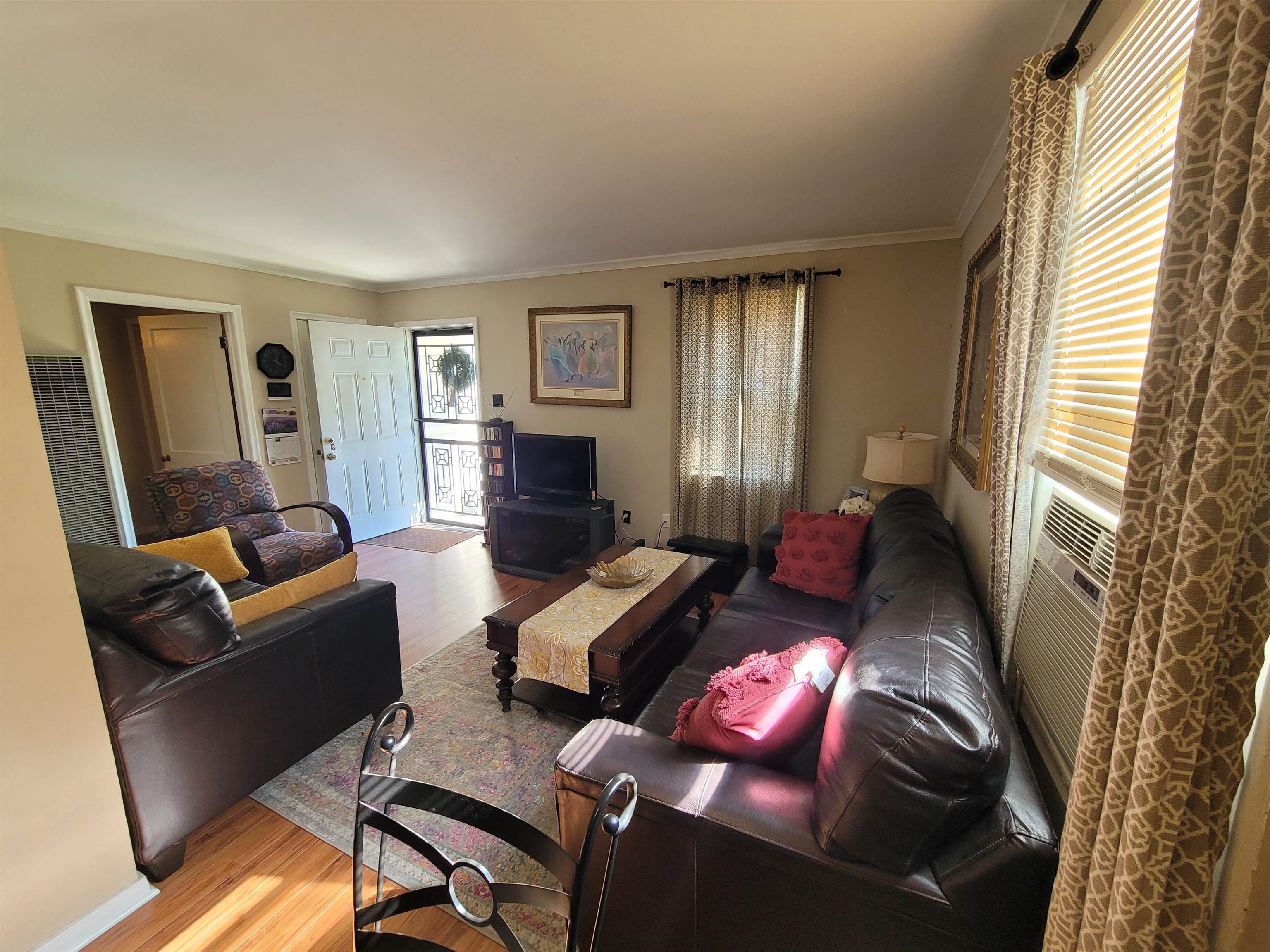 476 Jenson Road Memphis, TN 38109 - Photo 20 of 30 Living area featuring wood-finish flooring, light tan wall paint, and white crown molding