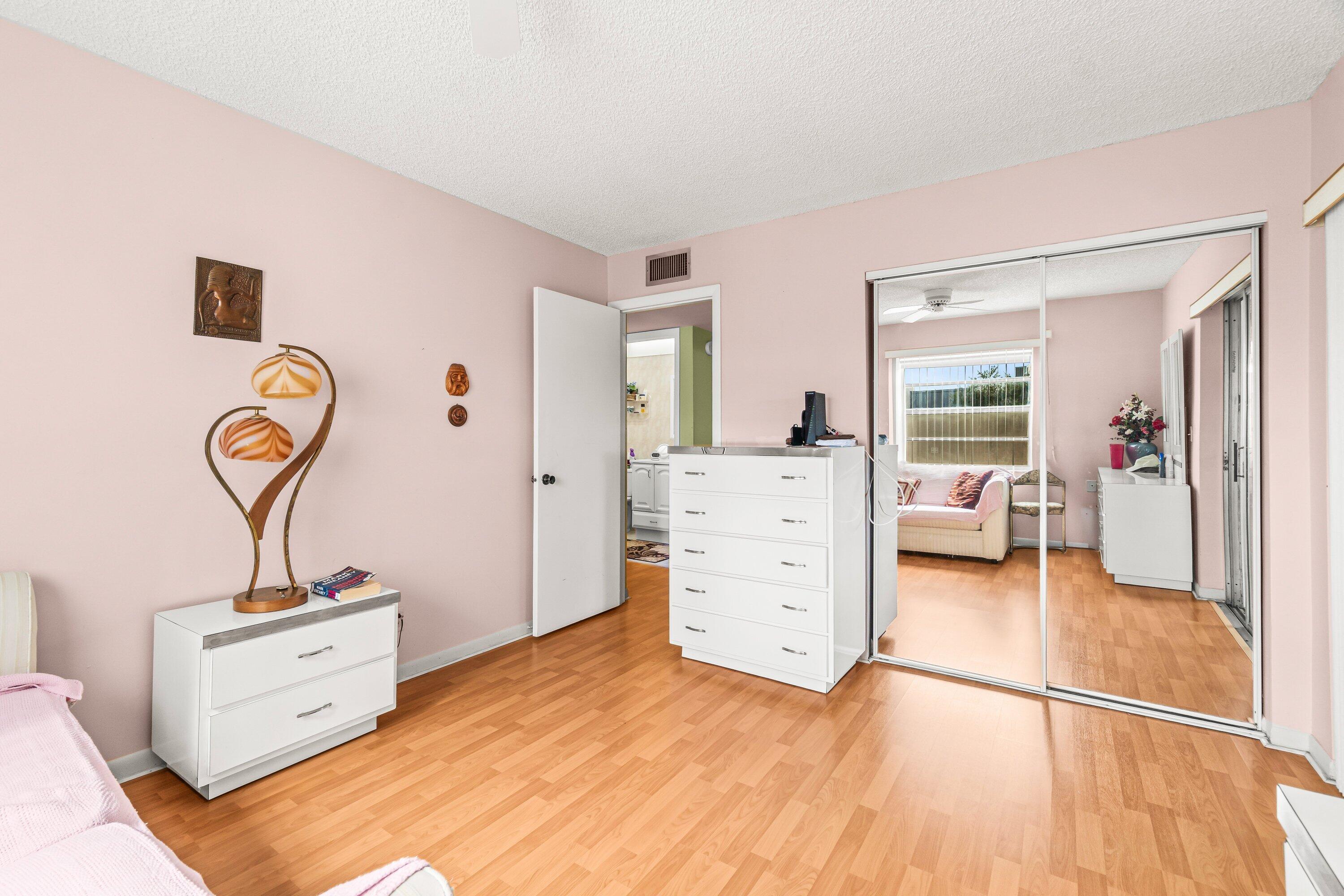 508 Normandy Lane, Unit 508 Delray Beach, FL 33484 - Photo 20 of 25 a view of a bedroom with bed and mirror