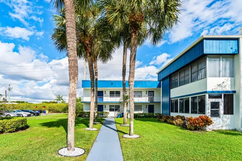 a view of a house with a yard and potted plants