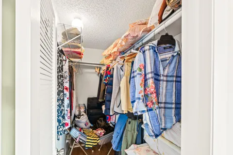 a view of walk in closet with clothes
