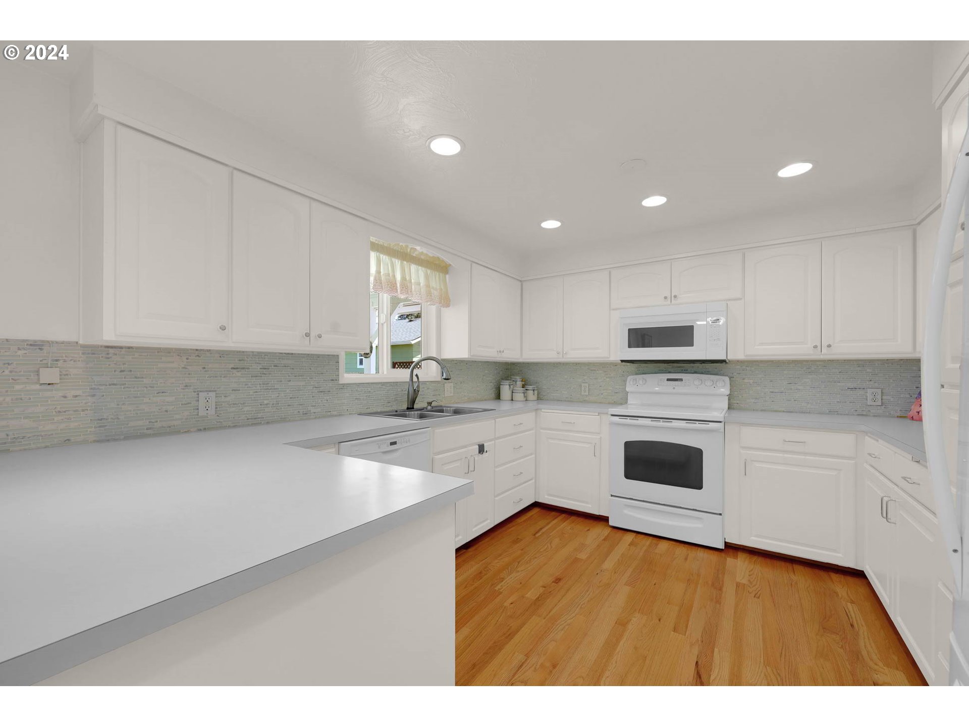 2411 15th Street Springfield, OR 97477 - Photo 3 of 18 a kitchen with granite countertop white cabinets and white appliances