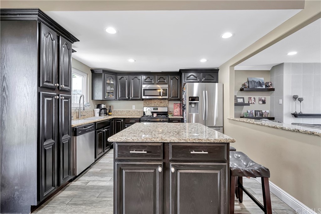 23682 Cavanaugh Road Lake Forest, CA 92630 - Photo 20 of 51 a kitchen with stainless steel appliances granite countertop a refrigerator a sink and a stove