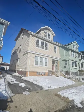 a view of a white building among the street with palm trees