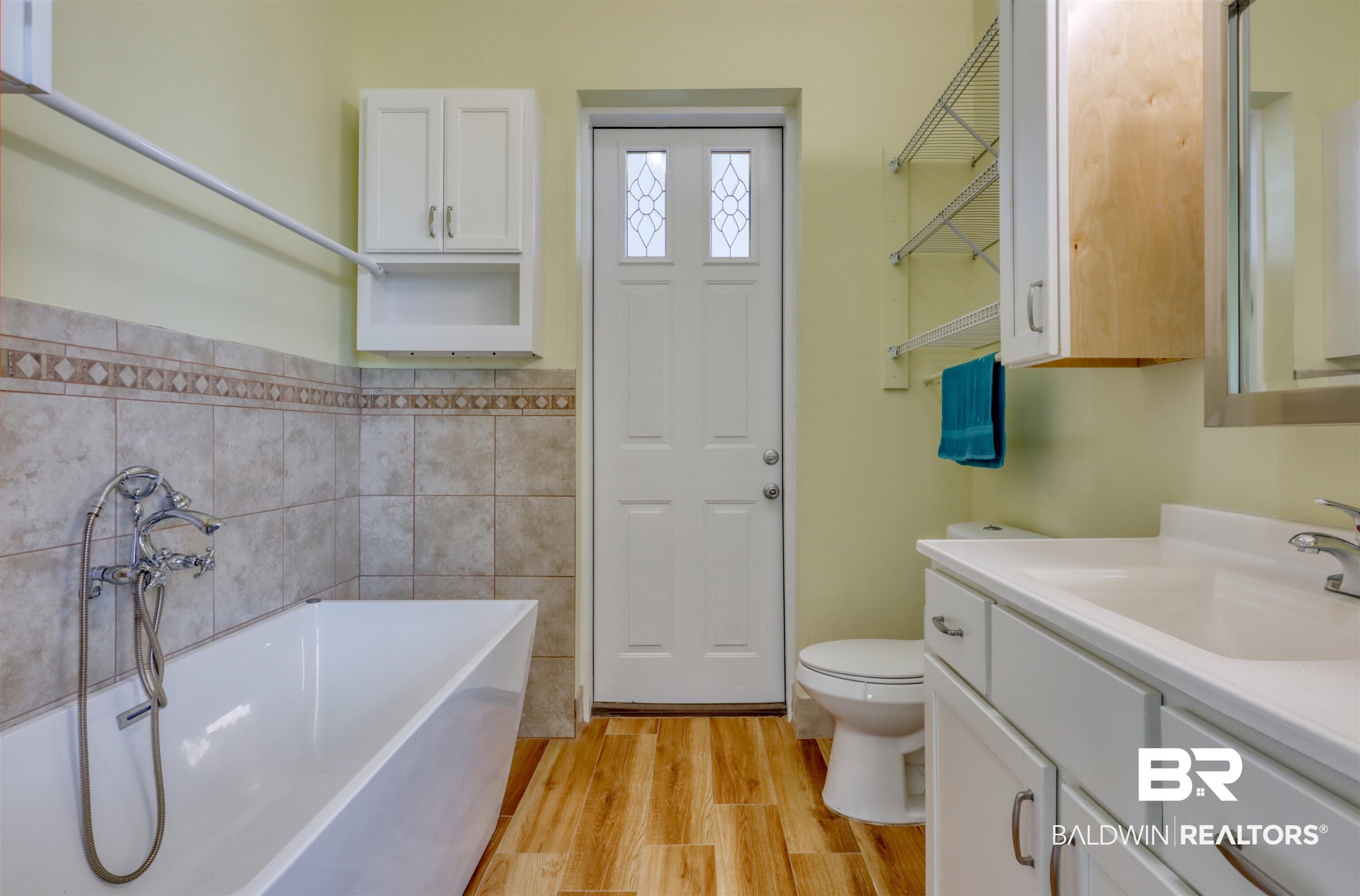 28461 Gardner Road Elberta, AL 36530 - Photo 12 of 46 Bathroom with vanity, light wood-style flooring, a freestanding bath, and tile walls