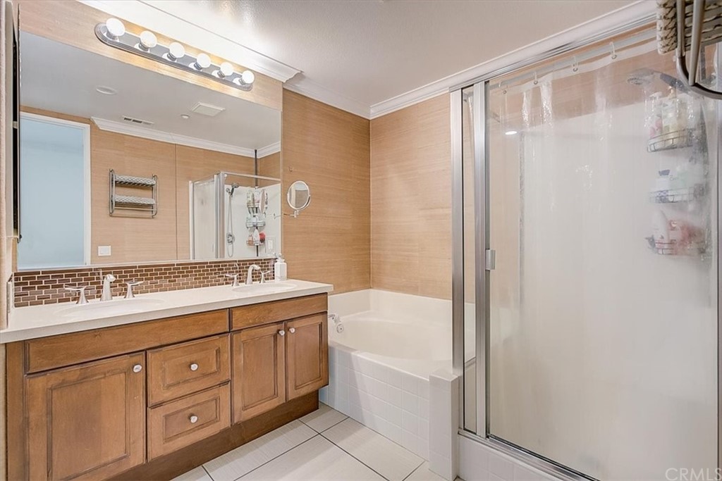 326 District Court Fullerton, CA 92832 - Photo 33 of 41 a bathroom with a granite countertop sink a mirror a bathtub and shower