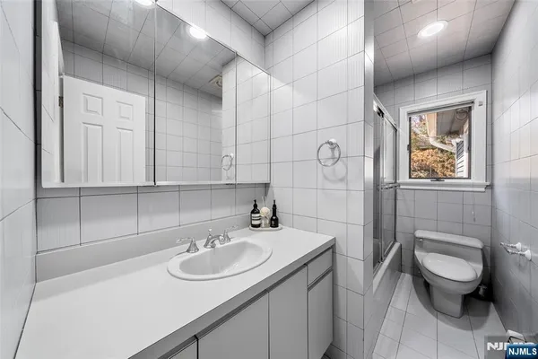 a bathroom with a sink toilet and a mirror