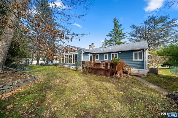 a view of a house with backyard and a tree