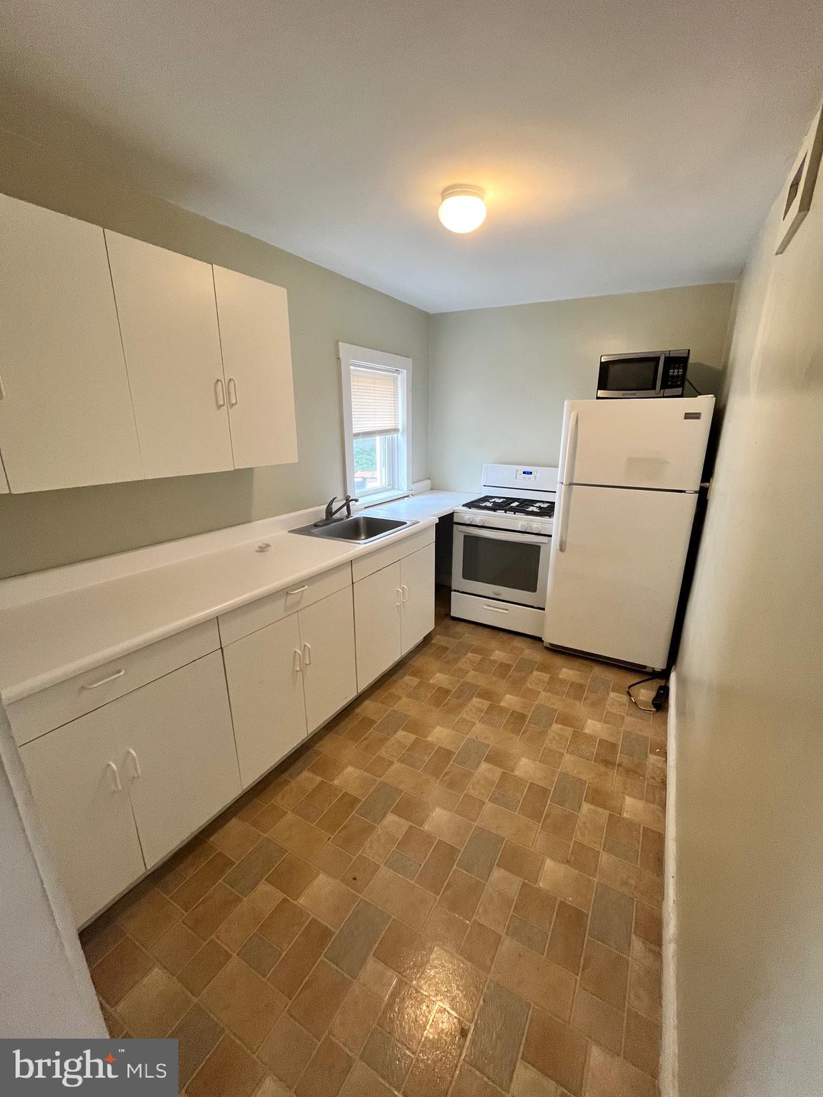 11 New Street, Unit 4 Newark, DE 19711 - Photo 6 of 16 a kitchen with a sink a stove top oven and white cabinets