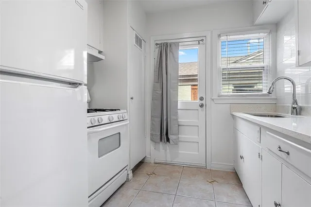 a kitchen with white cabinets and white appliances