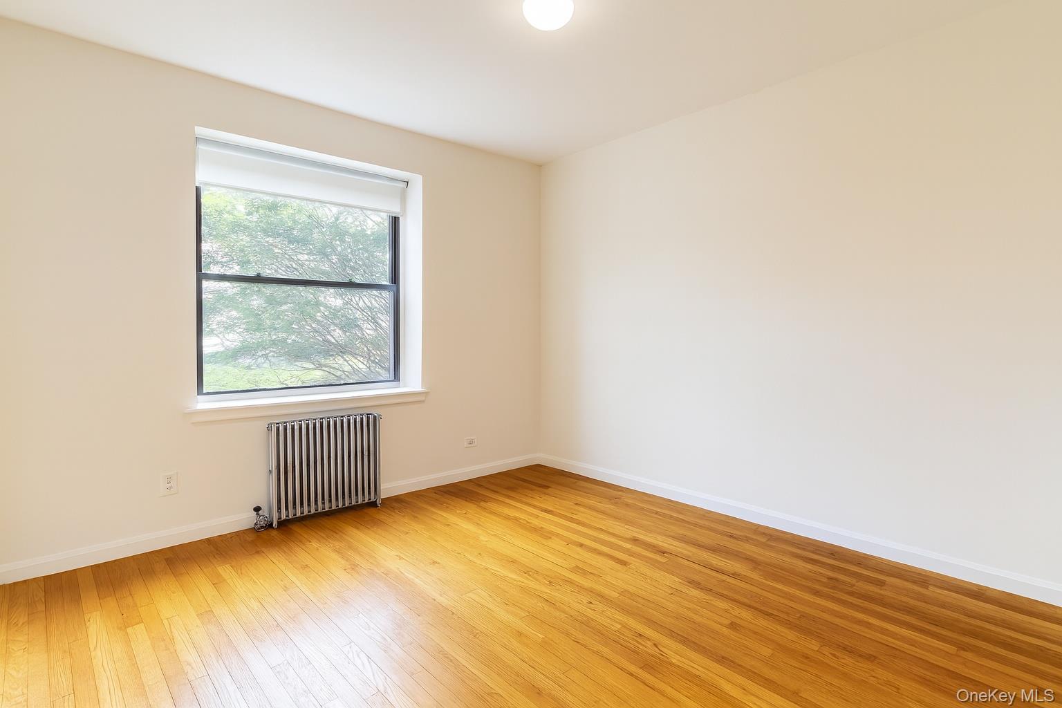 21-41 78th Street, Unit 1 Queens, NY 11370 - Photo 6 of 10 an empty room with a window