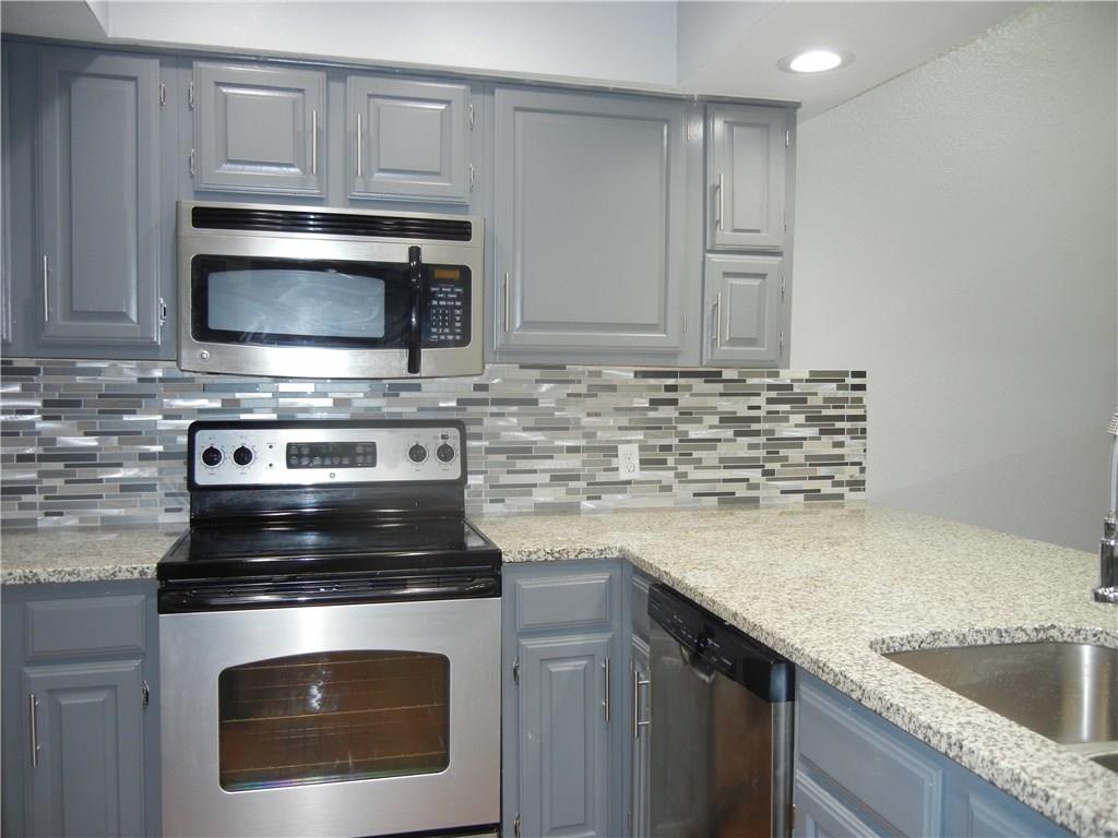 18240 Midway Road, Unit 105 Dallas, TX 75287 - Photo 3 of 37 a kitchen with granite countertop cabinets stainless steel appliances and a sink