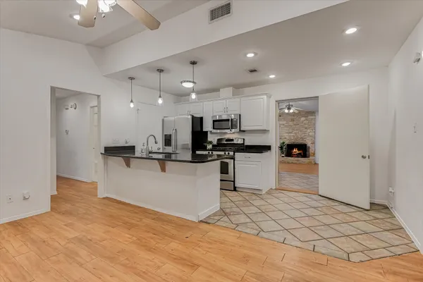 a kitchen with stainless steel appliances kitchen island granite countertop a refrigerator and a stove top oven