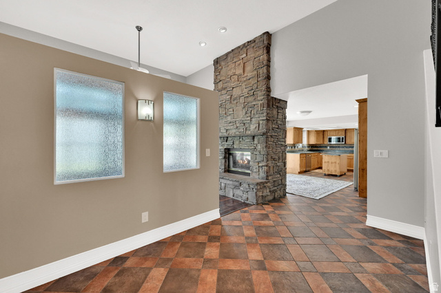4792 Glasmann Way South Ogden, UT 84403 - Photo 36 of 70 Stone fireplace with hearth, tile flooring, recessed lighting, and frosted windows