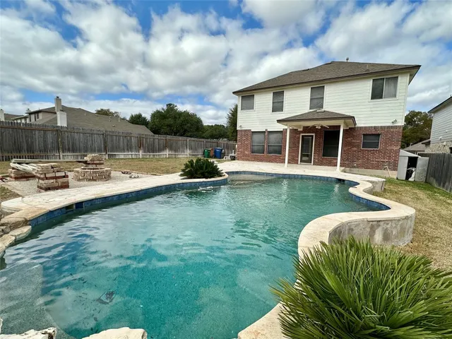 a view of a house with pool and chairs