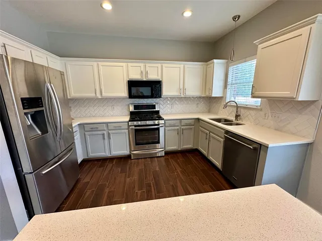a kitchen with a sink a stove a refrigerator and cabinets