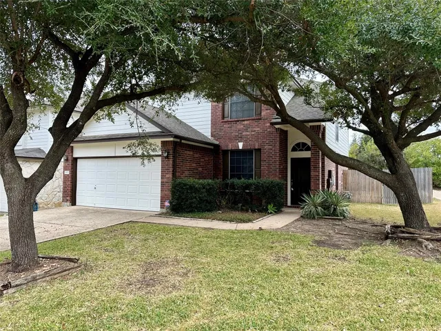a front view of a house with a yard and tree