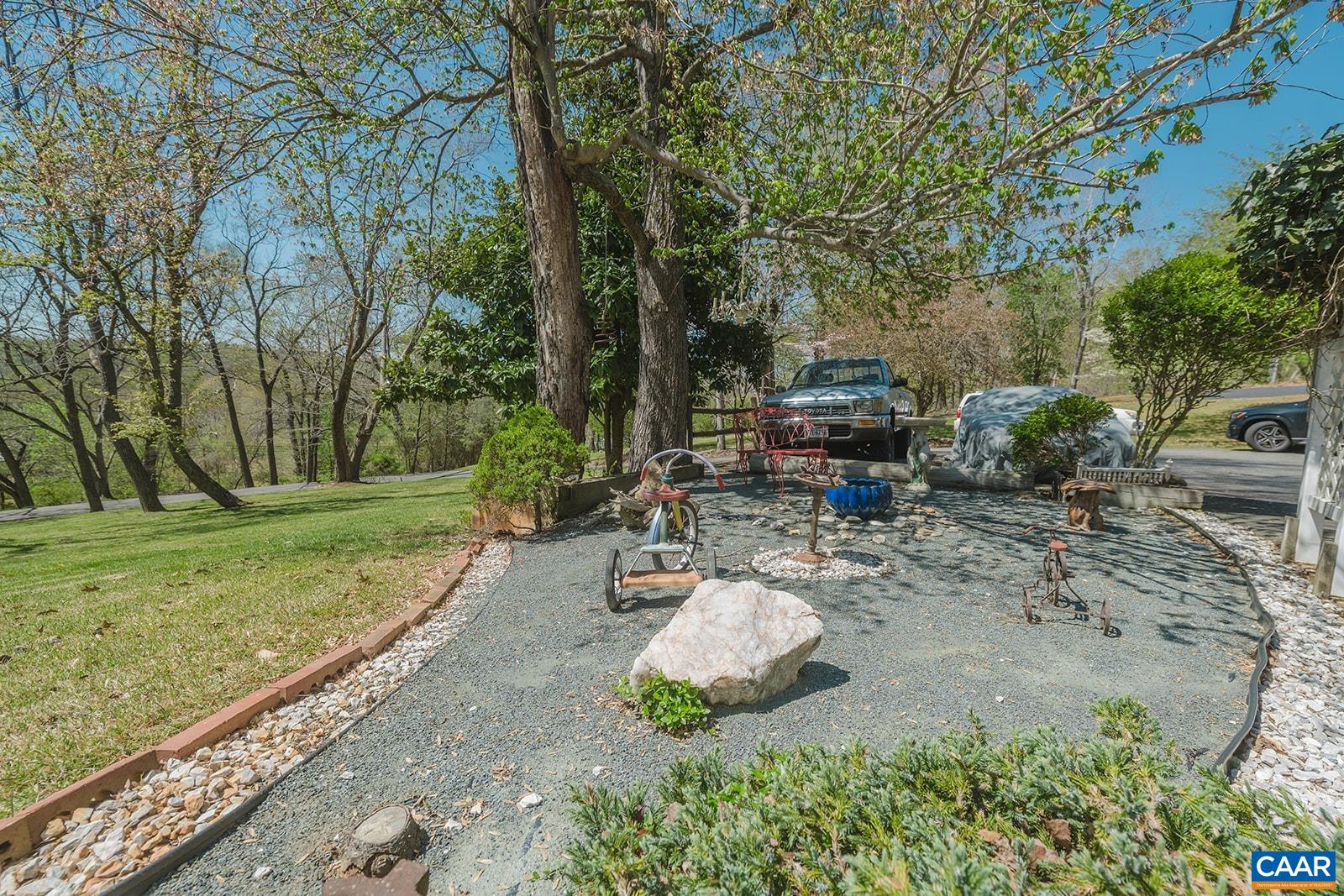 1642 Polo Grounds Road Charlottesville, VA 22911 - Photo 18 of 44 a view of a backyard with table and chairs plants and trees