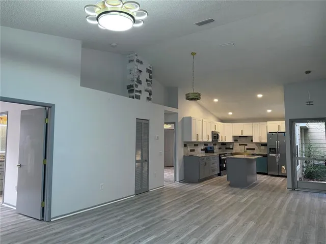 a kitchen with stainless steel appliances granite countertop a refrigerator and a stove top oven