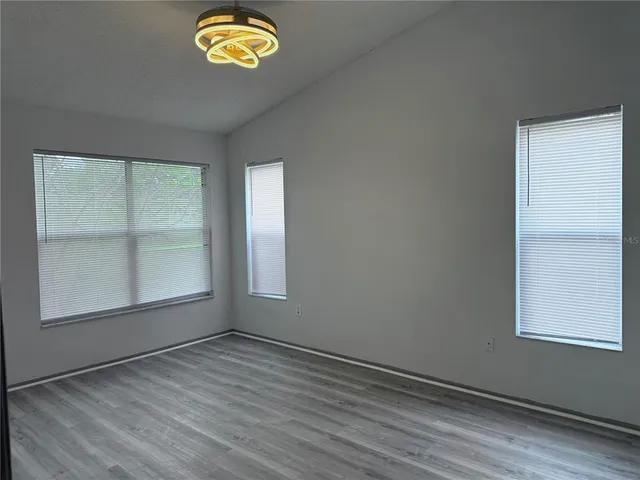 an empty room with a door and windows