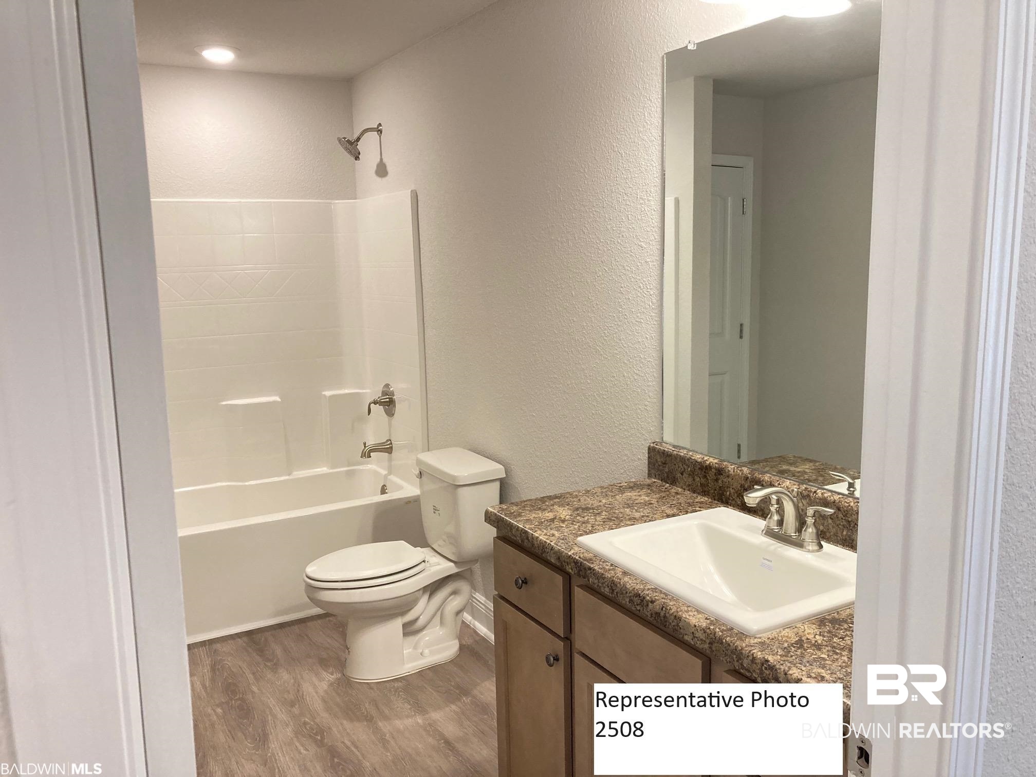 2201 Pollard Road Daphne, AL 36526 - Photo 9 of 15 Full bathroom featuring hardwood / wood-style floors, shower / bathtub combination, vanity, and toilet