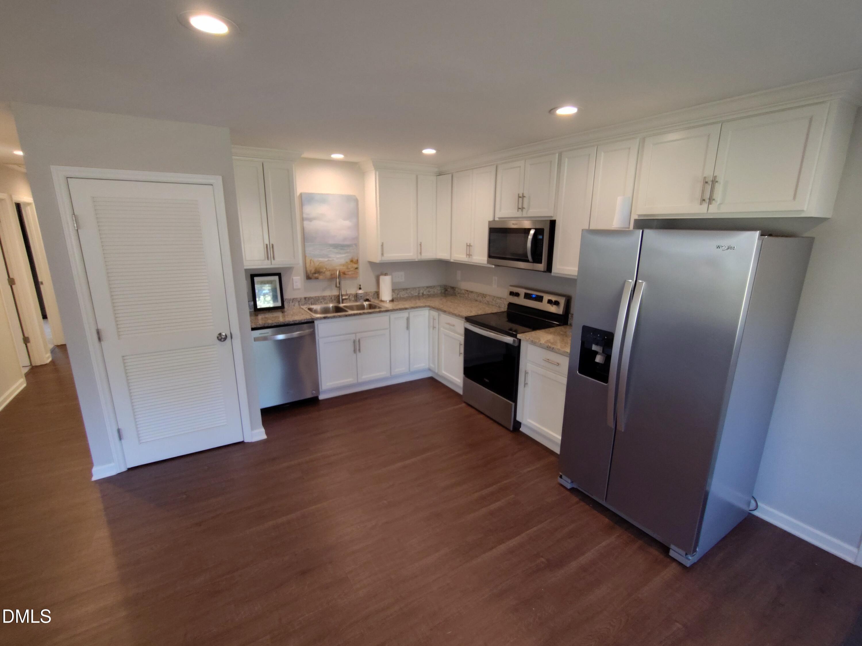 1202 Liberty Street Durham, NC 27703 - Photo 5 of 14 a kitchen with granite countertop a refrigerator and a stove top oven