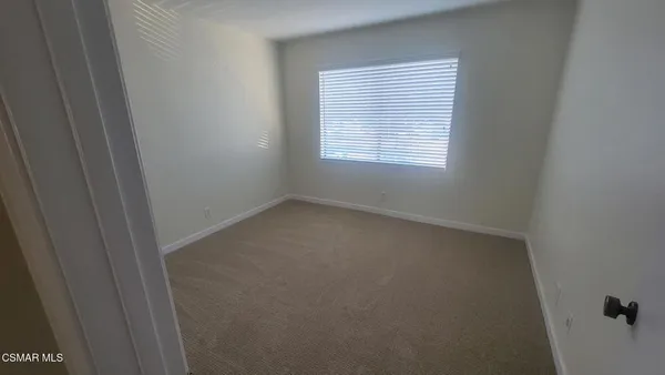 a view of a room with a ceiling fan and window
