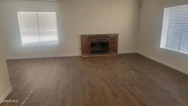 an empty room with a fireplace and a window
