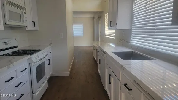 a kitchen with granite countertop a sink and cabinets