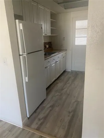 a view of a refrigerator in kitchen and wooden floor