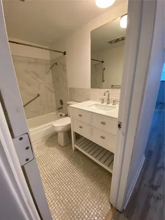 a bathroom with a granite countertop sink a toilet and shower