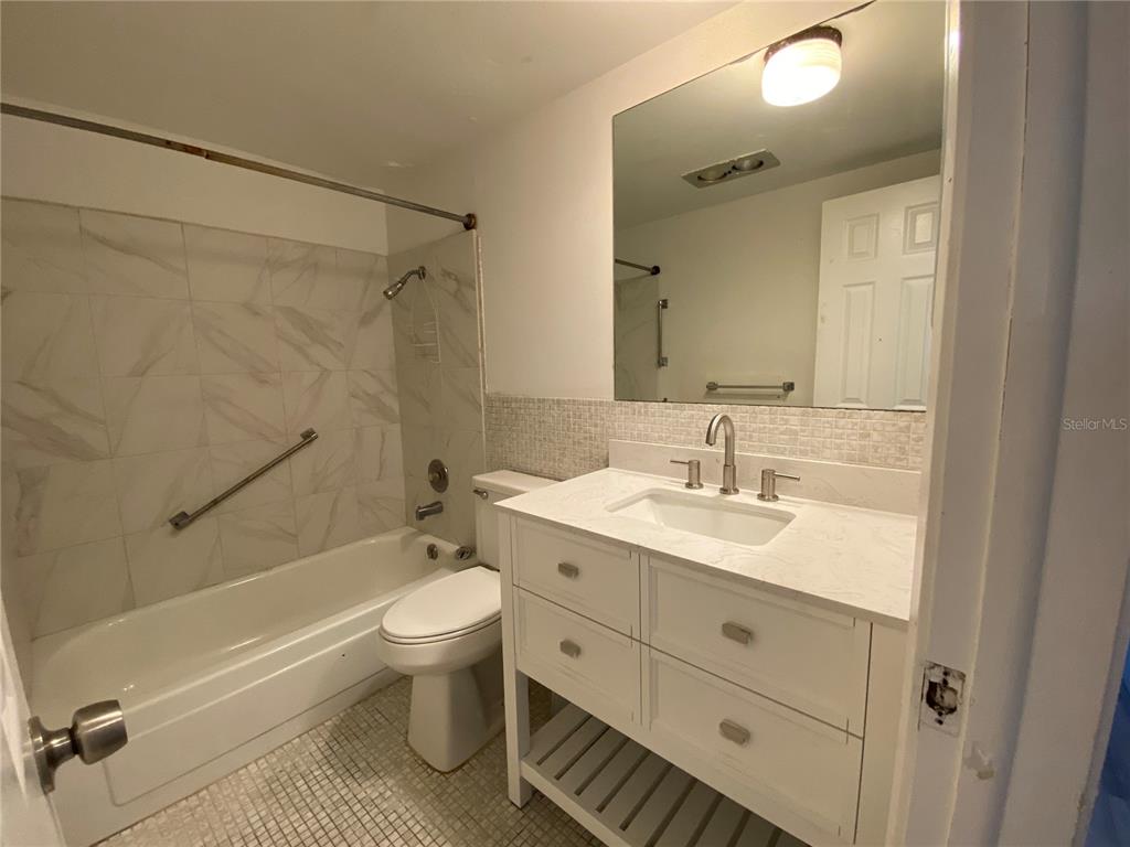 911 Washington Avenue Southwest, Unit 212 Largo, FL 33770 - Photo 9 of 20 a bathroom with a granite countertop sink a toilet and shower
