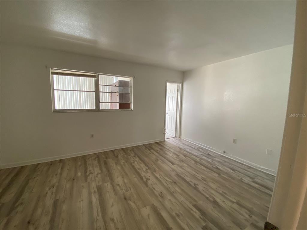 911 Washington Avenue Southwest, Unit 212 Largo, FL 33770 - Photo 10 of 20 an empty room with wooden floor and windows