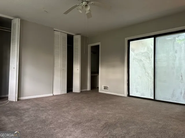 an empty room with chandelier fan