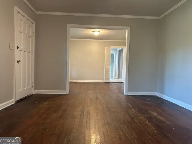 a view of a room with wooden floor and mirror