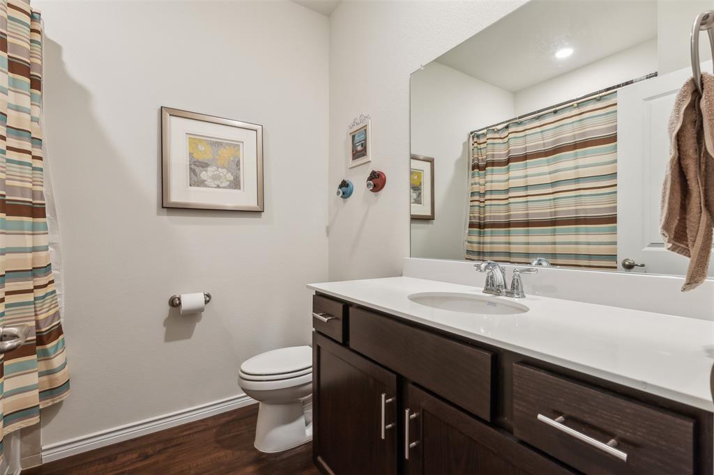 2607 Pinckney Court Forney, TX 75126 - Photo 14 of 27 a bathroom with a granite countertop sink toilet a large mirror and shower