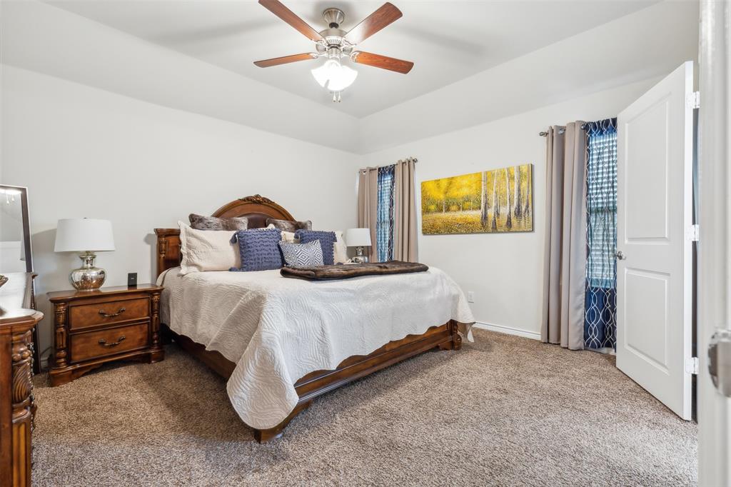 2607 Pinckney Court Forney, TX 75126 - Photo 8 of 27 a bedroom with a bed and a chandelier
